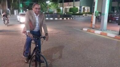 محافظ قنا يعود إلى استراحته مستقلاً دراجة بلا موكب ولا حراسة في مشهد استثنائي